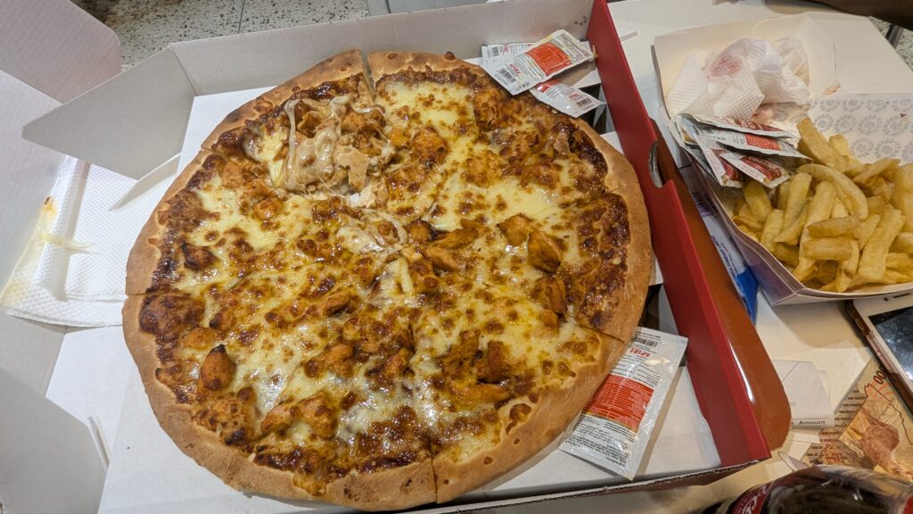 Takeaway pizza with fries and sauce packets